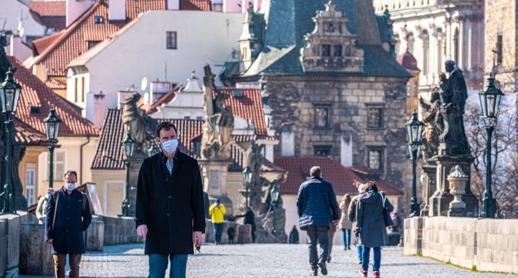 man wearing mask on the charles bridge in Prague during the pandemic
